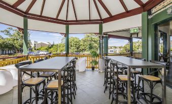 a covered outdoor dining area with several tables and chairs , providing a pleasant atmosphere for guests at Bayswater Tweed