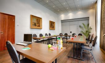 a conference room set up for a meeting , with several chairs arranged in a semicircle around a table at Hotel National