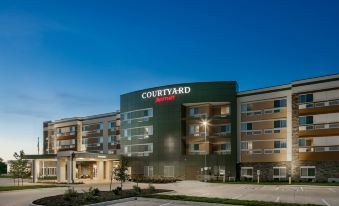 "a large hotel building with a green sign that reads "" courtyard by marriott "" prominently displayed on the front" at Courtyard Omaha Bellevue at Beardmore Event Center