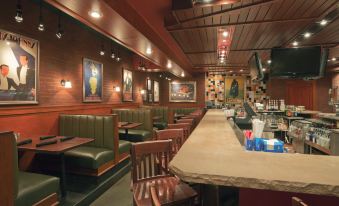 a restaurant with wooden booths and tables , a bar area , and various pictures on the walls at Holiday Inn Carbondale-Conference Center