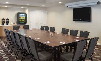 a conference room with a wooden table , chairs , and a television mounted on the wall at Sonesta ES Suites Nashville Brentwood
