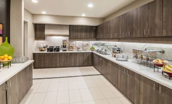 a modern kitchen with wooden cabinets , a marble countertop , and various appliances such as a microwave , toaster , and coffee maker at Residence Inn Rapid City