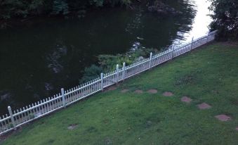 a white picket fence surrounding a body of water , possibly a lake or a river at The Waterford