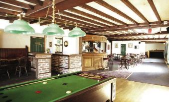 a pool table is set up in a room with wooden beams and a bar area at Malt House