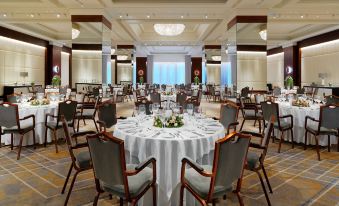 a large dining room with multiple tables and chairs arranged for a formal event or gathering at Athens Marriott Hotel