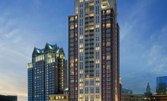 a tall , modern building with multiple stories and a large roof , situated in a bustling city at dusk at Omni Providence