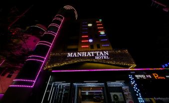 "a nighttime view of the manhattan hotel , a large building with a sign that reads "" manhattan hotel ""." at Manhattan Hotel