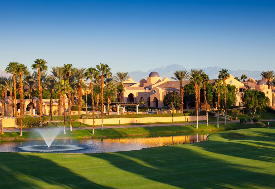a golf course with a fountain in the middle , surrounded by green grass and trees at The Westin Rancho Mirage Golf Resort & Spa