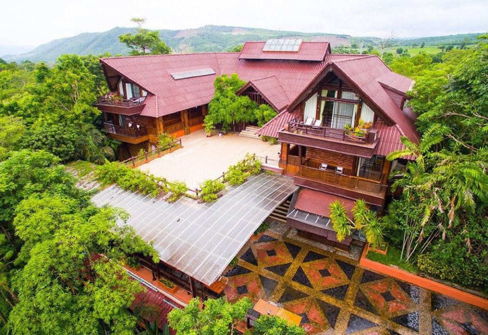 aerial view of a large wooden house surrounded by trees , with a pool in the backyard at Phu Pha Nam Resort