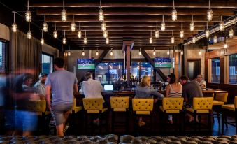 a group of people gathered in a dimly lit room , watching two soccer games on tv screens at Hotel Nyack, A Joie de Vivre Hotel by Hyatt