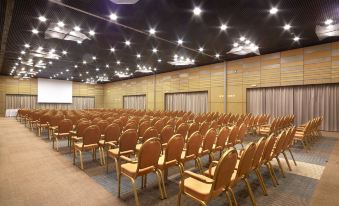 an empty conference room with rows of chairs and a projector screen , ready for an event or meeting at Ana Hotels Europa Eforie Nord