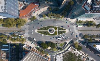 a bird 's eye view of a roundabout with cars and people driving around it , surrounded by buildings and trees at Le Meridien Mexico City
