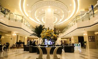 In the center of a spacious room, tables and chairs are illuminated by overhead lighting at Parsian Azadi Hotel