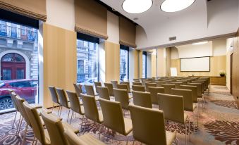 a large conference room with rows of chairs arranged in a semicircle , ready for a meeting at Hotel Moments Budapest