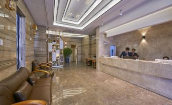 a modern hotel lobby with marble floors , a reception desk , and two people sitting behind it at Dubai Hotel