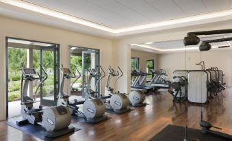 a well - equipped gym with various exercise equipment , including treadmills and stationary bikes , in a spacious room at Rosewood Sand Hill