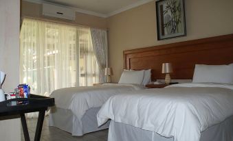 a hotel room with two beds , one on the left and one on the right side of the room at Mountain View Guest House