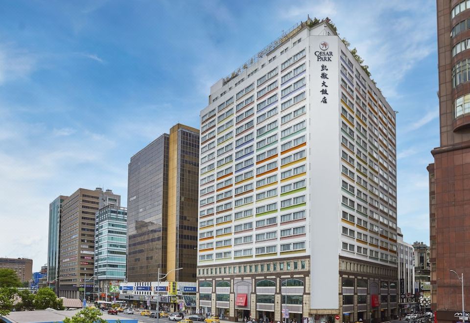 There is a large building in the center surrounded by other buildings, with one building located on the upper side at Caesar Park Hotel Taipei