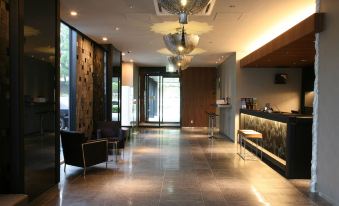 a modern , well - lit lobby with a reception desk and seating area , surrounded by wooden walls at Hotel Wing International Himeji