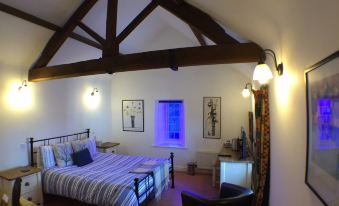 a spacious bedroom with a large bed , a desk , and a chair in the room at The White Hart
