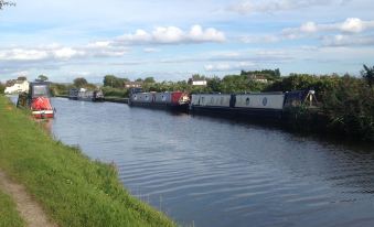 a body of water with several boats docked along the shore , creating a picturesque scene at The Farm Burscough