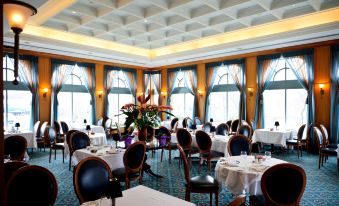 a large dining room with multiple tables and chairs arranged for a group of people to enjoy a meal together at The Waterside Inn