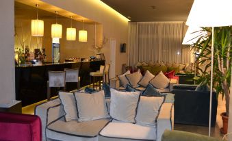 a modern living room with multiple couches and chairs , creating a cozy and inviting atmosphere at Cosmopolitan Hotel
