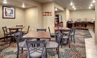 a dining area with several tables and chairs , as well as a counter and various appliances at Cobblestone Hotel & Suites - Erie