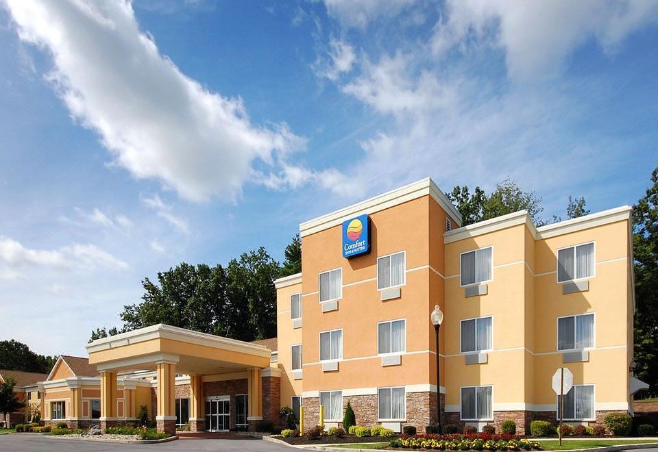 a comfort inn hotel with an orange exterior and a blue sign is shown in the image at Comfort Inn & Suites Saratoga Springs