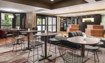 a modern office space with tables , chairs , and a couch , as well as a reception area and seating at Courtyard Dayton North