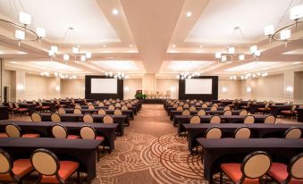 a large conference room with rows of chairs arranged in a semicircle , and a podium at the front of the room at Sheraton Orlando North Hotel