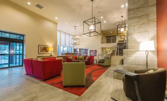 a large , modern hotel lobby with multiple couches and chairs arranged in a comfortable seating area at Hotel Mtk Mount Kisco