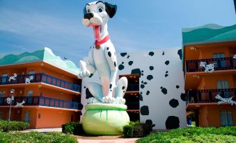 a large statue of a dog with a red collar is standing in front of a building at Disney's All-Star Movies Resort