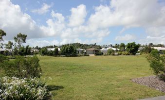 a large , open field with a house in the background and trees in the foreground at Direct Collective - Breeze on Brightwater