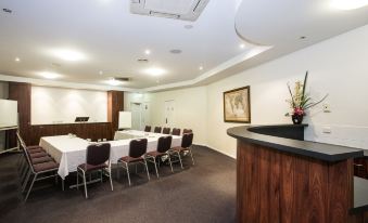 a conference room with a long table , chairs , and a counter , set up for a meeting at Coral Cay Resort