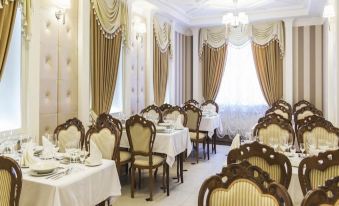a well - decorated dining room with tables and chairs arranged for a group of people to enjoy a meal at Metropol Hotel