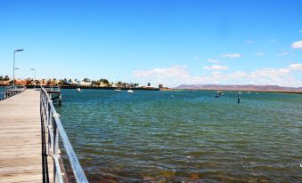 a boat docked on a body of water , with a pier extending into the water at Discovery Parks - Port Augusta
