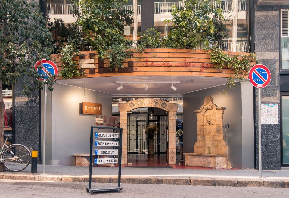 "a building with a wooden front and a sign that says "" no smoking "" is shown" at Hamra Urban Gardens