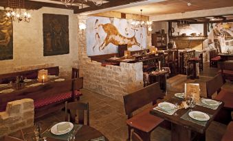 a restaurant with wooden tables , chairs , and a bar , as well as a painting on the wall at Bluesun Hotel Elaphusa