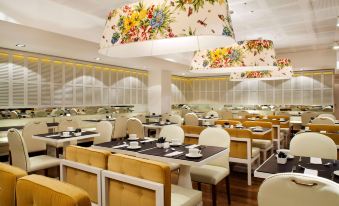 a restaurant with multiple tables and chairs , all of which have floral cushions on them at Hotel Pulitzer Buenos Aires