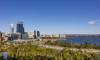 a panoramic view of a city with tall buildings and a body of water in the background at Quest Kings Park