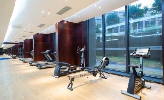 The hotel features a spacious gym with large windows and an exercise area that is both indoors and outdoors at Continental Bridge Convention Centre Lianyungang China