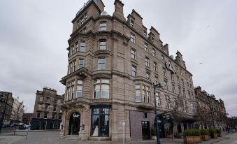 "a large , ornate building with a balcony on the side and a sign that says "" malmaison "" is situated on a street corner" at Malmaison Dundee
