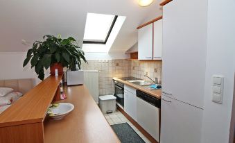 a kitchen with a wooden counter , white cabinets , and a sink , next to a window at Anita