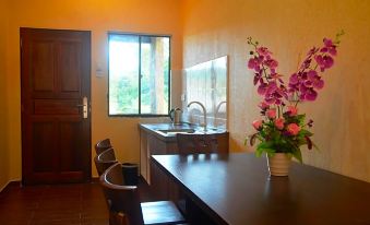 a dining room with a wooden table , chairs , and a vase of flowers on the table at Refarm