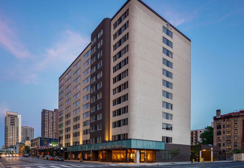 a tall building with a brown and beige facade is situated in front of another building at DoubleTree Suites by Hilton Minneapolis
