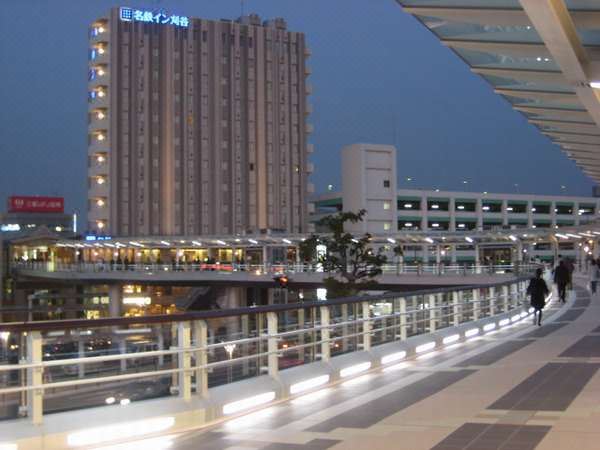a modern cityscape with a tall building and a bridge , illuminated at night , under the blue sky at Meitetsu Inn Kariya