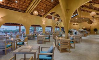 a modern restaurant with wooden furniture , including tables and chairs , arranged in an open space at Lahana Resort Phu Quoc & Spa