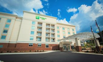 "a large white hotel building with a sign that reads "" holiday inn express "" prominently displayed on the front" at Holiday Inn & Suites Arden - Asheville Airport