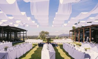 a large outdoor event space with tables and chairs set up for a wedding reception at Estate Tuscany